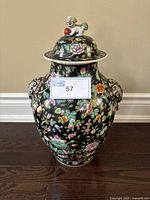 Full front view of the vintage Asian floral pattern vase with lid and Foo dog figurine on top, showing the intricate floral design and side handles.