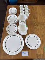 Top-down view of the entire dish set neatly arranged on the table showing all plates, bowls, and cups.