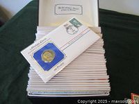 View of stacked first day covers with presidential medals and postage stamps showing Abraham Lincoln medal prominently.