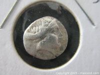 Close-up photo of the obverse side of the ancient silver coin featuring the bust of Histiaia wearing an ivory head-dress.
