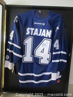 Front of the framed blue jersey showing name, number and autograph