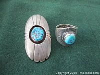 Ring and brooch on green cloth background