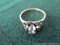 Top view of ring on green background showing center diamond and side stones