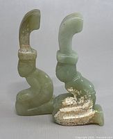 Front and side views of two kneeling men jade figurines showing their shape, color, and natural surface marks.