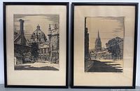 Photo of two framed black and white engravings showing architectural scenes, each in black frames with cream mats, displayed side by side.