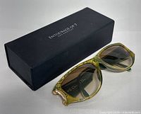 Sunglasses and black Entourage of 7 For Angels case displayed together