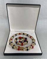 Necklace, bracelet and earrings arranged in black box with white interior