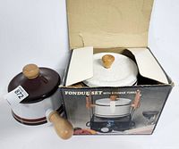 Fondue pot, lid, and original box shown with wooden handle and knob, brown stripe decoration.