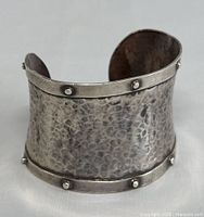 Front angle of the hammered silver cuff bracelet detailing texture and rivet accents.