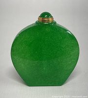 Front view of the natural green jade perfume or snuff bottle showing smooth polished surface and rounded shape.