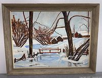 Full view of framed winter landscape painting showing snow, trees, barns, and a church steeple.
