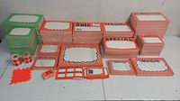 Stacks of orange bordered blank merchandising/pricing signs with some printed Sale, Special, Advertisement text; green bordered blank signs; small labels and rolls of pricing stickers visible.