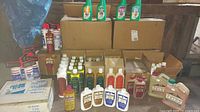 Wide view showing all cleaning chemicals grouped on a table, including various bottles and boxed cases.