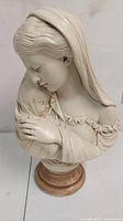 Front view of the chalkware bust showing Madonna holding Infant Jesus with detailed facial features and clothing folds, mounted on wooden base.