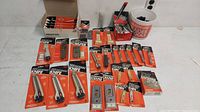 Overview of assorted new old stock razor cutters, scrapers, breakaway knives, and other blade tools in original packaging laid out on a white surface.