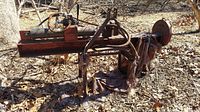 Wide side view of vintage Brave hydraulic log splitter showing main beam, hydraulic ram and mounting frame with rust and wear.