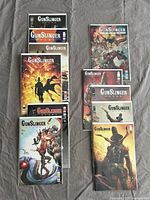 Top-down view of all 10 GunSlinger Spawn comics arranged on fabric background, showing variety of cover art.
