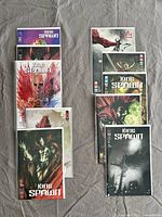 Photo of 9 King Spawn comic books arranged on a surface showing front covers with varying artwork styles.
