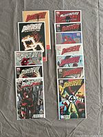 Lot of 13 Daredevil comic books arranged on a grey fabric background, front covers visible.