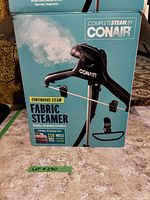 Box for Conair Complete Steam Fabric Steamer with image and steam effect, showing brand and model details.