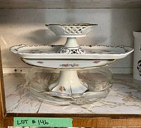 Stacked display of China serving platter (bottom), JL Menau footed cake plate (middle), and small JL Menau bowl (top), along with the etched glass serving bowl underneath them all.