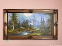 Full view of the framed painting showing the nature landscape in detailed color with gold frame and dark velvet trim.