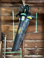 Full view of the Yardworks electric leaf blower showing long nozzle, handle, and small wheel.