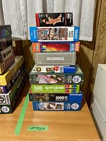 Stack of 9 boxed puzzles showing brands and piece counts