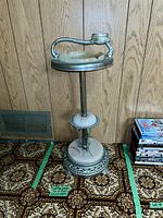Full view of vintage metal ashtray stand showing height and base design