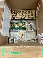 Top-down photo of the box containing all vintage Canadian military buttons, pins, cufflinks, and medals in organized compartments.
