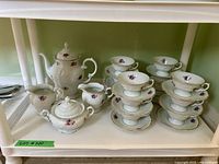 Full display of the Wawel porcelain tea set with all cups, saucers, teapot, sugar bowl, and creamer arranged on shelf