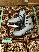 Side view of silver and black CCM women's ice skate size 9 showing blade and adjustable ankle strap.