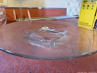 Close-up of large round glass platter showing surface pattern and small glass ball details on edge