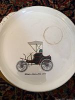 Vintage automobile plate featuring Winter Schactelie 1898 car illustration on white ceramic with gold trim.