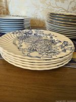 Side view of stacked Towle Limoges dessert plates with fruit and floral blue design.