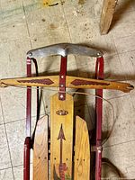 Original Flexible Flyer sled with red metal frame and wooden slats, showing intact paint and markings.