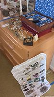 Overall view of two wooden jewelry boxes on dresser, loose jewelry pieces and white hanging mesh organizer displayed.