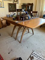 Overall view of table with leaves removed, showing angled support legs and tabletop surface.
