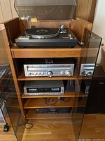 Full stereo system including turntable, receiver, tape deck, equalizer and speakers on wooden shelving