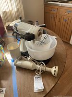 Sunbeam Mixmaster stand mixer with three glass bowls stacked inside one another and beaters attached to the mixer.