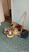 Full lot with assorted tins, boxes, fabric, yardsticks, and bag of sewing supplies on patterned carpet