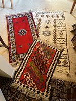 Three various patterned throw rugs laid overlapping on floor showing colors, designs and size.
