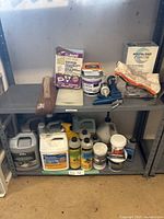 Shelf with assortment of grout powders, tubes, and cleaning liquids
