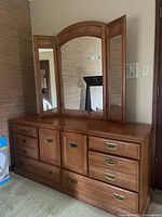 Front view of large oak dresser with tri-fold mirror showing drawer and door layout