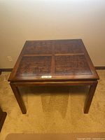 Full view of square wooden card table showing inlaid wood top and sturdy legs.