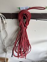 Photo of long red extension cord coiled and hanging on wall.