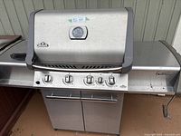 Front view of closed grill on cart with two doors and side shelves