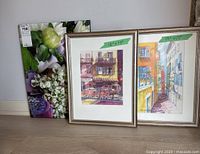 Overview photo showing all three pieces: floral canvas and two framed art prints, with size notes taped on the prints.