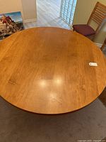 Top view of round wooden dining table showing smooth surface and 60 inch diameter