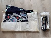 Kimono partially folded with beaded accessory in box on light wood floor